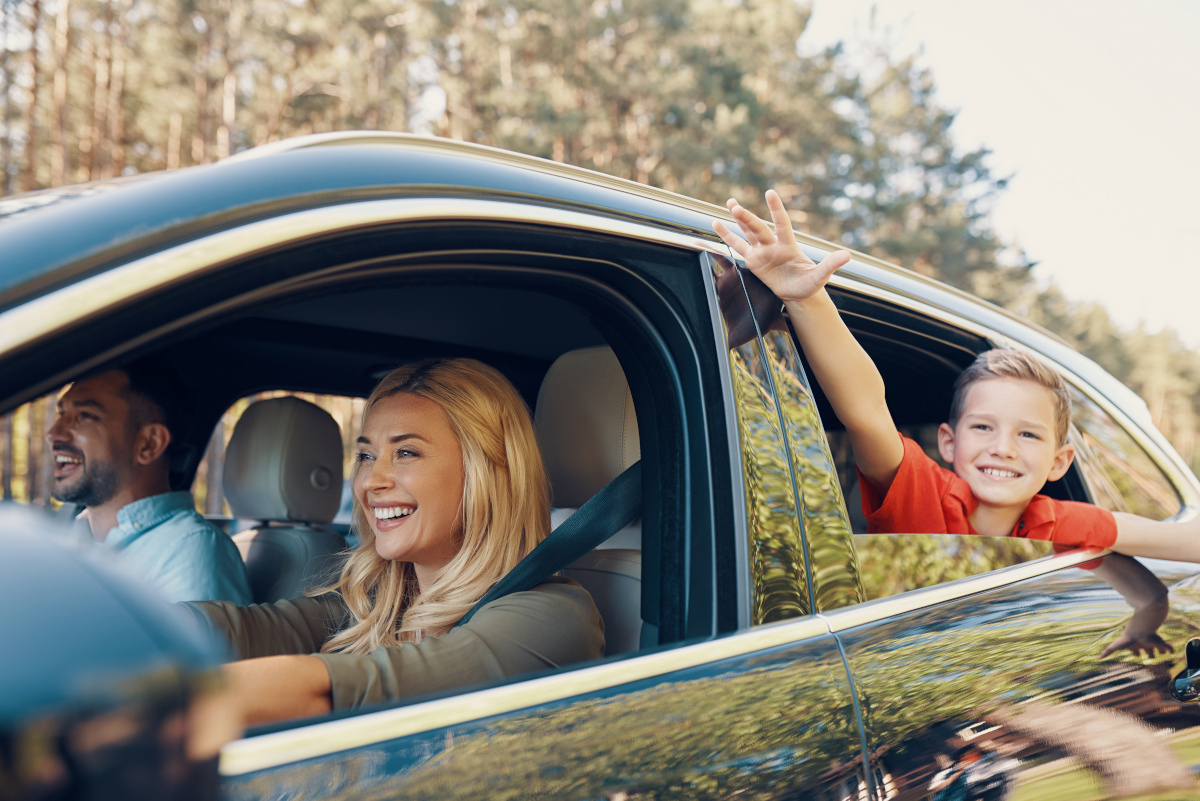 Happy Family Driving in Car Happy family driving with child waving, protected by Onust aftermarket warranty