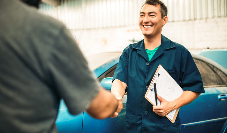 Mechanic Shaking Hands With Satisfied Customer Mechanic shaking hands with happy customer after car repair, backed by Onust coverage